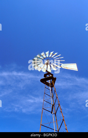 Meubles anciens de style ferme Aermotor moulin pour pomper de l'eau siège contre un ciel bleu, Midwest USA Banque D'Images