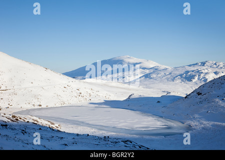 Vue de Moel Siabod à partir de l'ensemble piste mineurs Teyrn congelés Llyn Lake dans les montagnes de Snowdonia National Park, au nord du Pays de Galles au Royaume-Uni. Banque D'Images