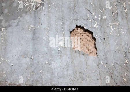 Un vieux mur en stuc charlottes loin, révélant un encore plus vieux mur de briques d'adobe, sous de Carrizozo, Nouveau Mexique. Banque D'Images