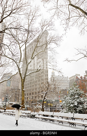 Flatiron Building hiver tempête marcher avec parapluie Banque D'Images