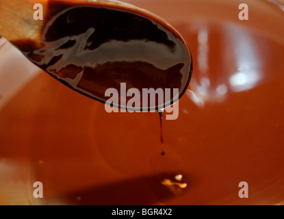 Le chocolat fondu avec cuillère à mélange Banque D'Images