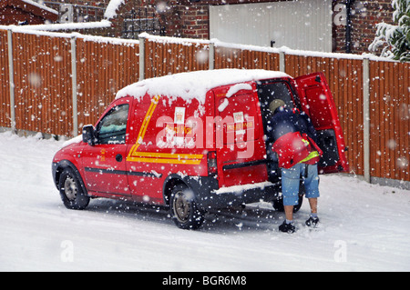 Froid hiver neige sur la livraison de Royal Mail postman travail de la camionnette de poste dans la scène résidentielle de rue dans la tempête de neige Brentwood Essex Angleterre Royaume-Uni Banque D'Images