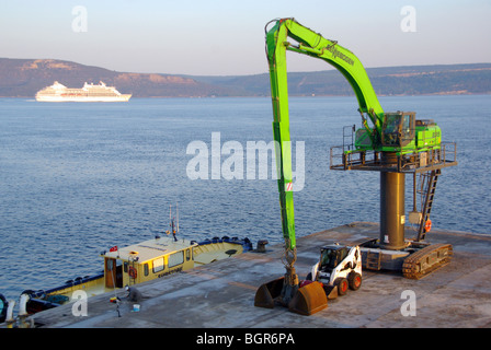 Véhicule à chenilles de grue mobile de chantier naval Canakkale avec chenilles stationnées sur le quai à côté du petit chargeur Turquie Asie Banque D'Images