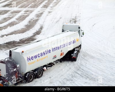 Le ravitaillement en carburant des aéronefs sur l'aire de travail de Bowser à l'aéroport de Newcastle avec neige au sol Banque D'Images