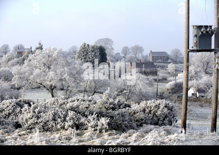 Vue d'un paysage d'hiver gelé avec un transformateur d'électricité au premier plan. Banque D'Images