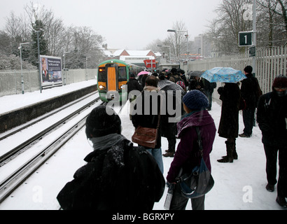 Les banlieusards attendent leur train durant les chutes de neige à une station service dans le sud de Londres, UK Banque D'Images