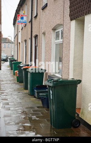 Wheelie bins sur la chaussée à l'extérieur des maisons mitoyennes à Newport South Wales UK Banque D'Images