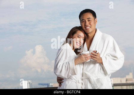 Jeune couple dans des robes hugging and smiling Banque D'Images