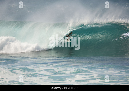 Un sufer conduit une grande vague, à l'intérieur du baril, au pipe-line, North Shore, Oahu, Hawaii Banque D'Images