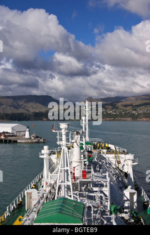 Un petit transporteur de produits départ de port comme vu dans cette vue de la passerelle du navire Lyttelton, Nouvelle-Zélande. Banque D'Images