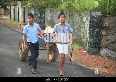 2 jeunes garçons tirant une charrette, Kerala, Inde Banque D'Images