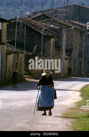 L'Espagne. Vieux village andalou woman walking passé un projet de construction. Banque D'Images
