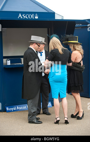 Deux couples portant des tenues et chapeaux à Royal Ascot Banque D'Images