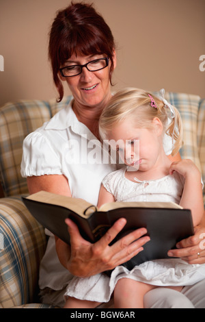 La lecture de la bible d'une grand-mère à sa petite-fille Banque D'Images