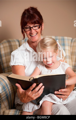 La lecture de la bible d'une grand-mère à sa petite-fille Banque D'Images