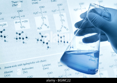 Concept scientifique--Scientist holding fiole avec un liquide sur une base scientifique. Banque D'Images