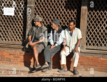 Trois hommes népalais de Katmandou Durbar Square, regardant les passants Banque D'Images