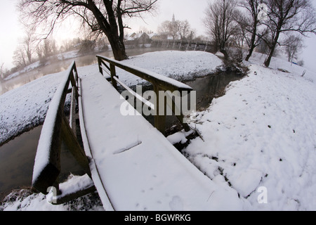 Froid matin d'hiver par la rivière avec petite ville en arrière-plan. Banque D'Images