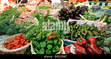 PARIS, France — Un marché parisien en plein air dynamique présente une gamme de produits frais. Les fruits et légumes colorés sont agencés avec art dans divers stands, tandis que les vendeurs et les acheteurs locaux interagissent dans cette scène traditionnelle du marché français. Banque D'Images