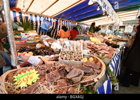 PARIS, France — Un marché parisien en plein air dynamique présente une gamme de produits frais. Les fruits et légumes colorés sont agencés avec art dans divers stands, tandis que les vendeurs et les acheteurs locaux interagissent dans cette scène traditionnelle du marché français. Banque D'Images