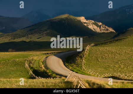 Chemin rural et de montagnes baignées de soleil spectaculaire-Rocky Mountain Front, Montana Banque D'Images