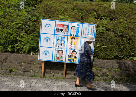 Les piétons passent devant les affiches des candidats du parti politique, de la publicité leur candidature pour les élections de la ville de Tokyo. Banque D'Images