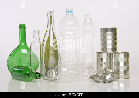 Les bouteilles en verre et en plastique et des boîtes en fer blanc photographié sur un fond blanc. Banque D'Images