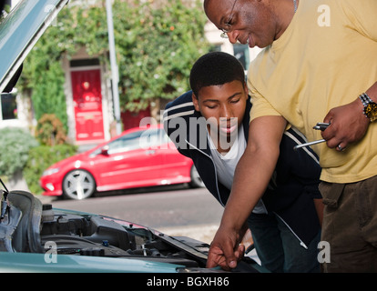 Père & Fils travaillant sur le moteur de voiture Banque D'Images