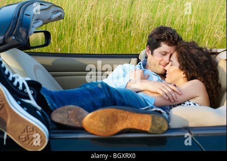 Couple laying dans un cabriolet Banque D'Images