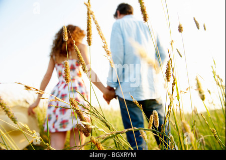 Couple holding hands in a wheat field Banque D'Images