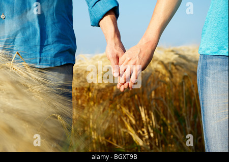 Couple holding hands in a wheat field