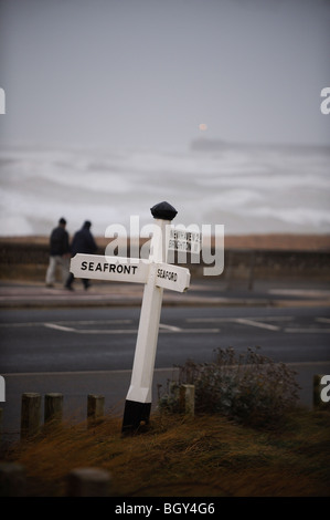 Deux marcheurs braver les éléments comme les tempêtes d'hiver lash le front de mer de Seaford East Sussex, Royaume-Uni. Photo Jim Holden. Banque D'Images