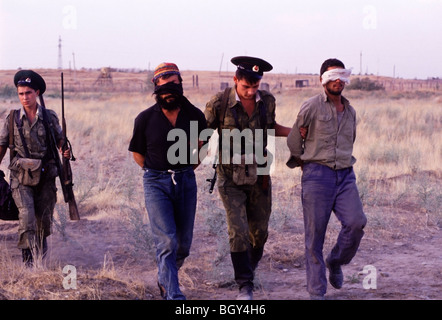 Escorte des soldats russes capturés et les yeux bandés de Tadjiks et d'armes à feu pour les passeurs afghans leur base dans Pyandsh, au Tadjikistan. Banque D'Images