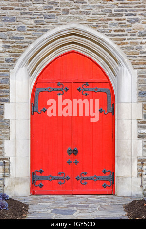 Portes de l'église rouge sur une vieille église en pierre Banque D'Images