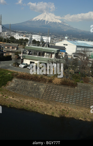 Le Mont Fuji, vu derrière un fond de paysage agricole et industriel, d'un shinkansen train à grande fenêtre, le Japon. Banque D'Images