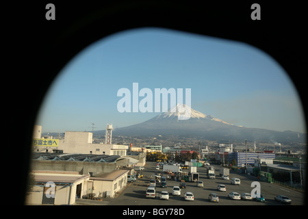 Le Mont Fuji, vu derrière un fond de paysage agricole et industriel, d'un shinkansen train à grande fenêtre, le Japon. Banque D'Images