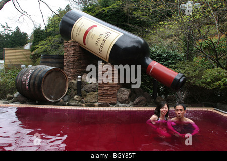 Couple de se baigner dans la 'red' vin ( baignoire, un bain contenant du vrai vin rouge), à Hakone Kowakien Yunessun à Tokyo, Japon Banque D'Images