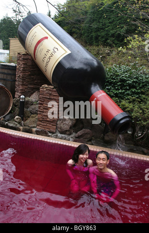 Couple de se baigner dans la 'red' vin ( baignoire, un bain contenant du vrai vin rouge), à Hakone Kowakien Yunessun à Tokyo, Japon Banque D'Images