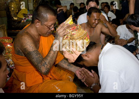 L'un des cultes les plus étranges : au Wat Bang Phra, un moine bouddhiste dévots bénit Banque D'Images