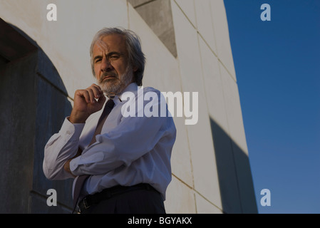 De businessman looking at camera, low angle view Banque D'Images