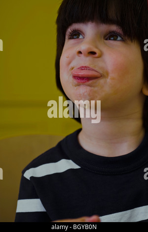 Petit garçon avec visage malpropre sticking out tongue Banque D'Images