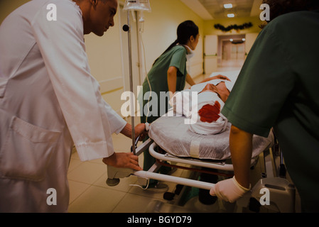 Les travailleurs de la santé le transport d'un blessé sur brancard, cropped Banque D'Images