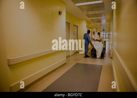 Les travailleurs de la santé de traiter le patient on gurney in hospital corridor Banque D'Images