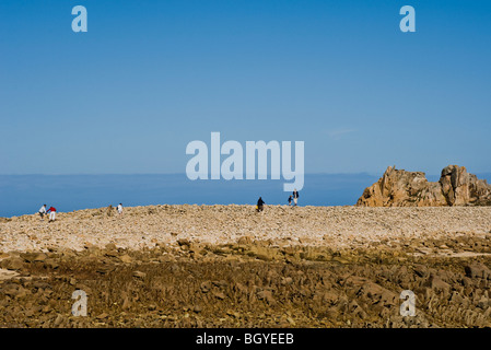 Les touristes explorant coastal rock formation Banque D'Images