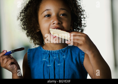 Little girl eating snack Banque D'Images