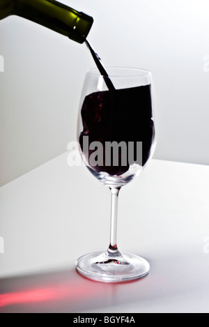 Concept alimentaire, verser le vin dans le verre de vin d'imitation Banque D'Images