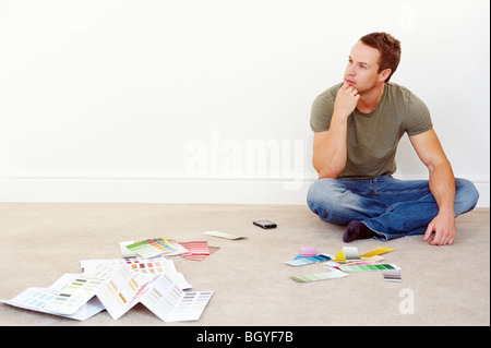 Homme assis au sol avec les échantillons de couleur Banque D'Images