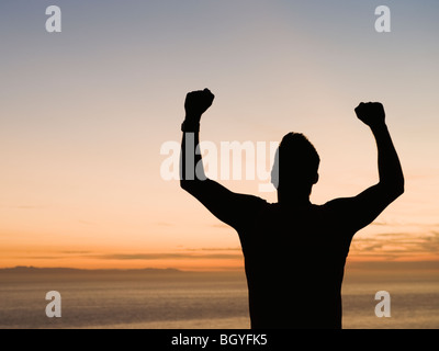 Silhouette of man raising arms Banque D'Images