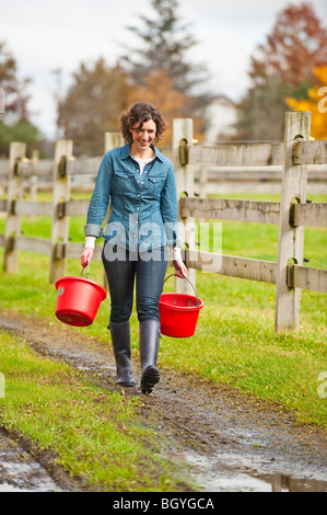 Femme transportant des seaux Banque D'Images