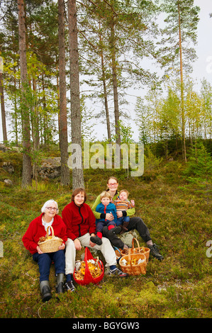 Famille avec des paniers de champignons dans la forêt Banque D'Images